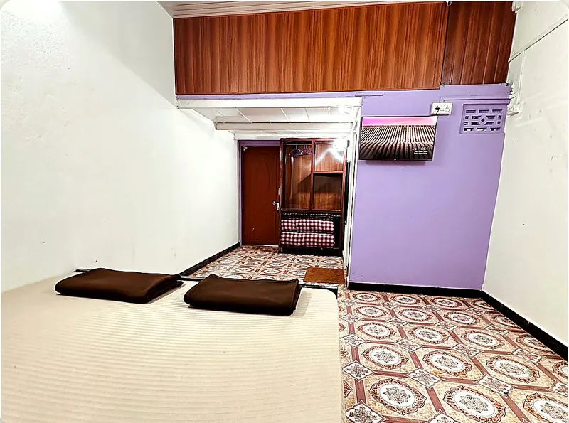 Room 3 at Konkan Central Homestay, Kankavli: king bed with split AC on the lilac wall