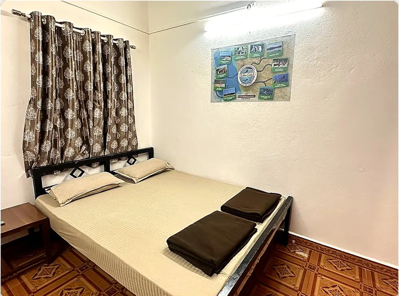 Room 4 at Konkan Central Homestay, Kankavli: queen bed and patterned curtain